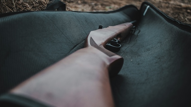 An air rifle laying on a gun bag