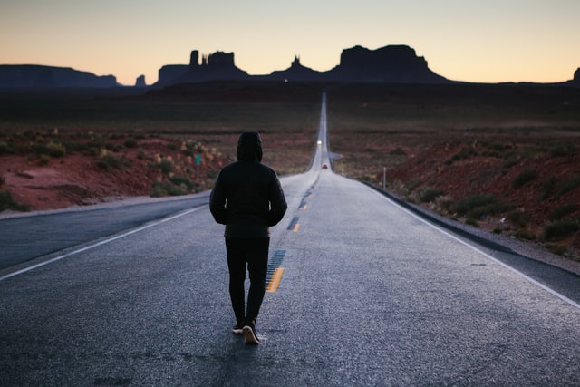 A person walking down a long highway